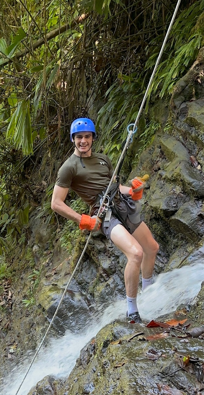 Climber rappelling beside a waterfall